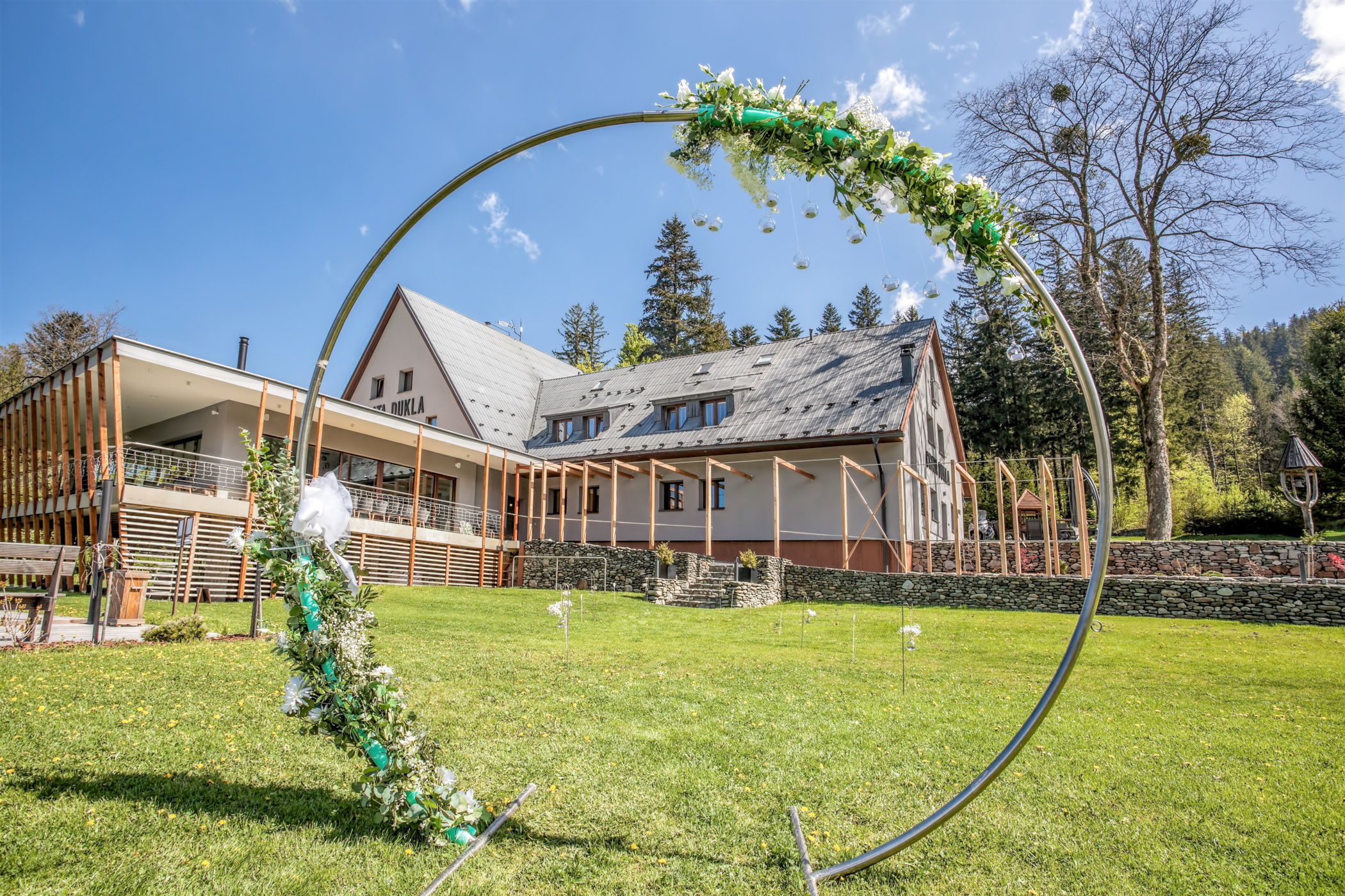 Obřadní kruh s výzdobou na Chatě Dukla — venkovní obřadní místo s chatou v pozadí