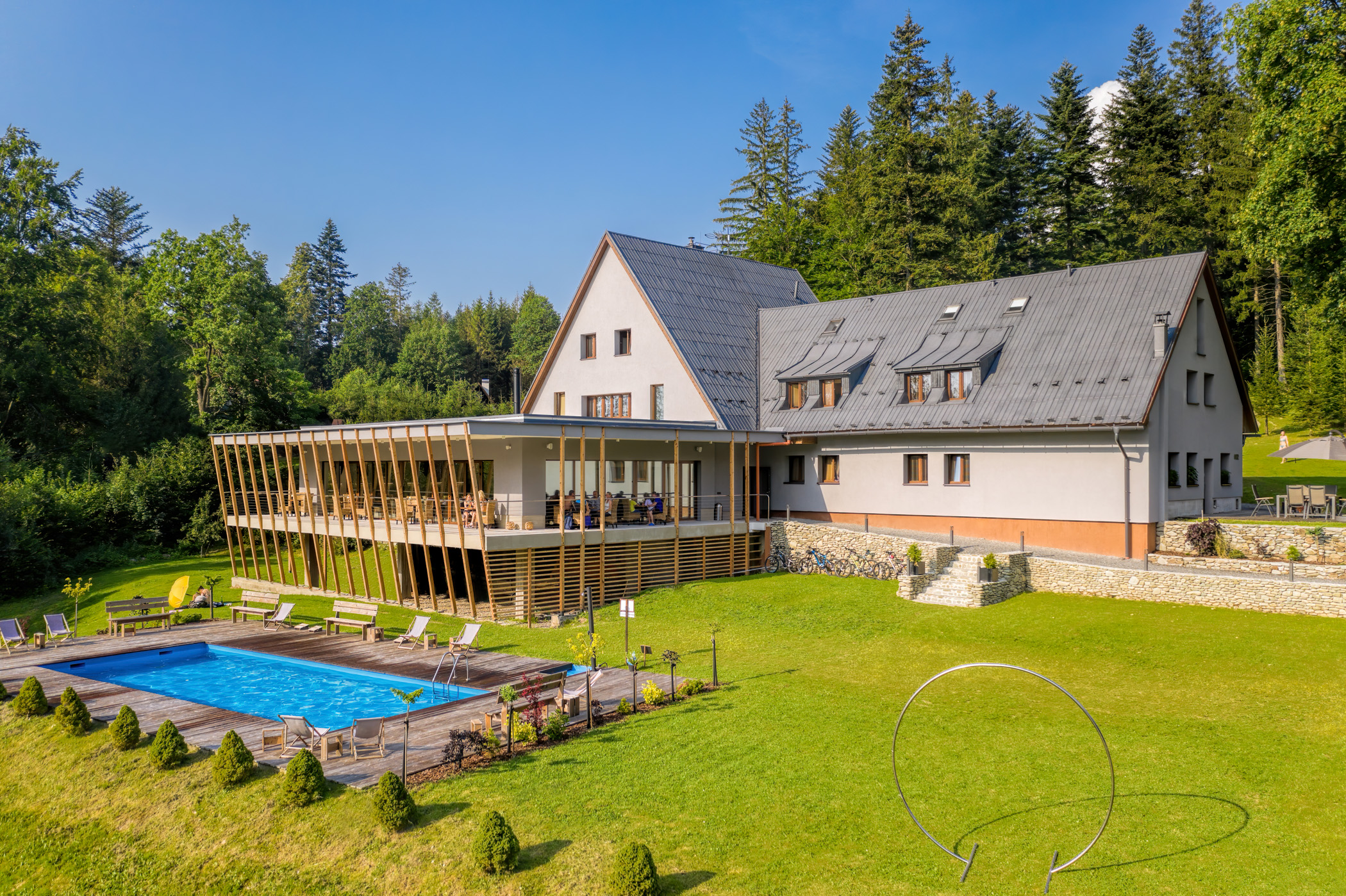 Chata Dukla z dronu — areál s bazénem obklopený beschydskými lesy v létě