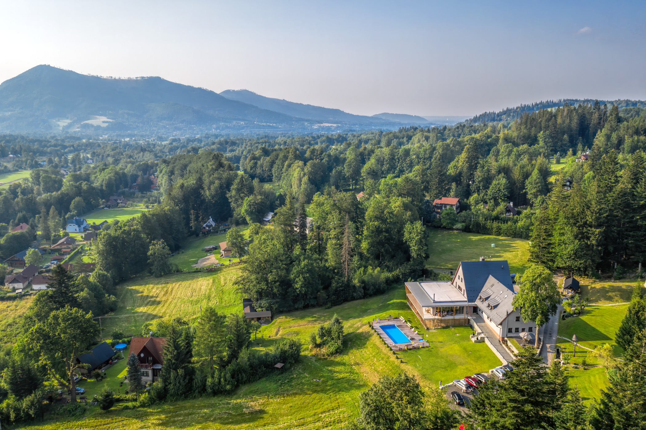 Letecký pohled na Chatu Dukla v Horní Čeladné s beskydskými horami v pozadí